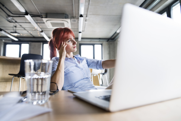 Beautiful businesswoman with laptop in her office.