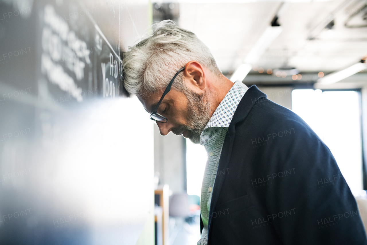 Disappointed or worried mature businessman in the office.