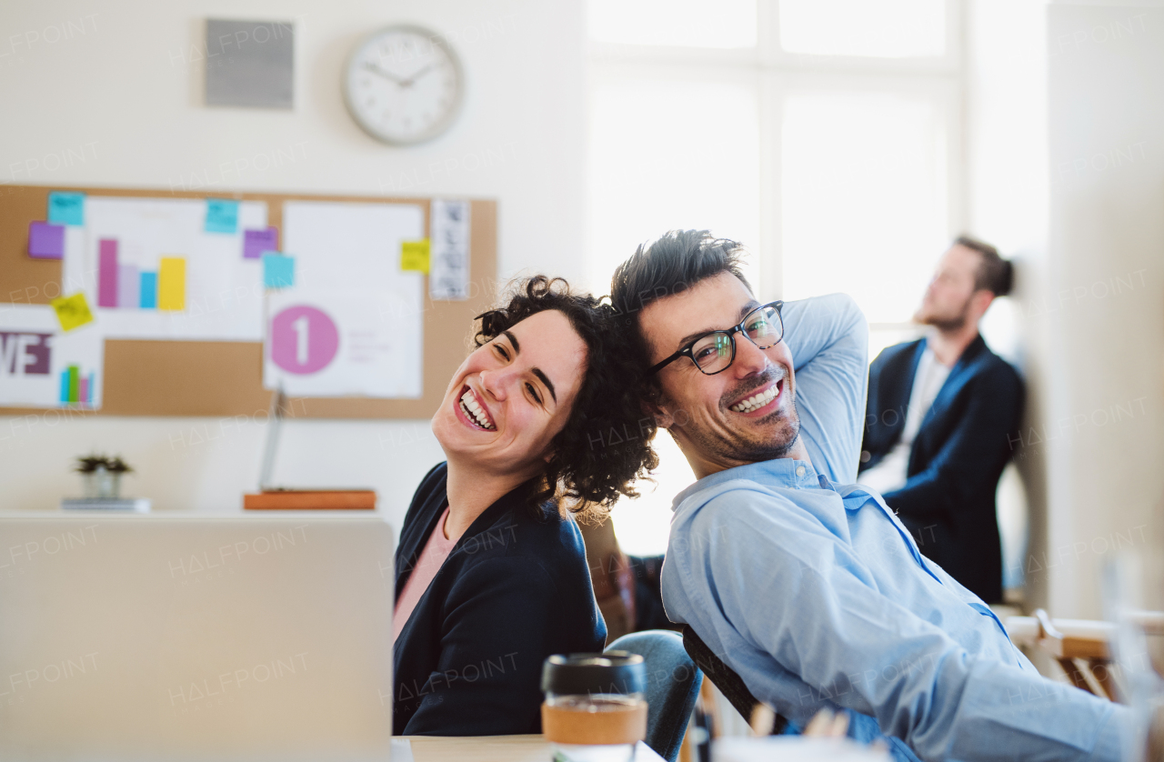 Group of young, cheerful, male and female businesspeople working together in a modern office.