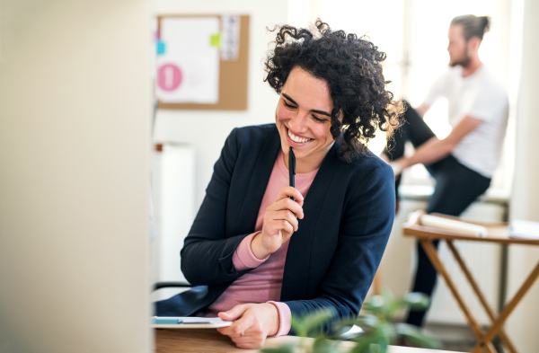 A portrait of cheerful young businesswoman working in a modern office.