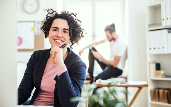 A portrait of young businesswoman sitting in a modern office. Copy space.