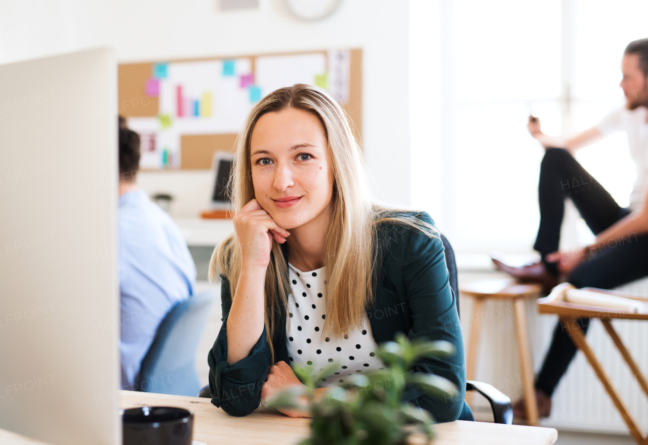 A portrait of young businesswoman sitting in a modern office. Copy space.