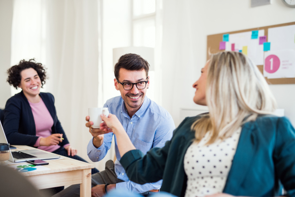 Group of young, cheerful, male and female businesspeople working together in a modern office.