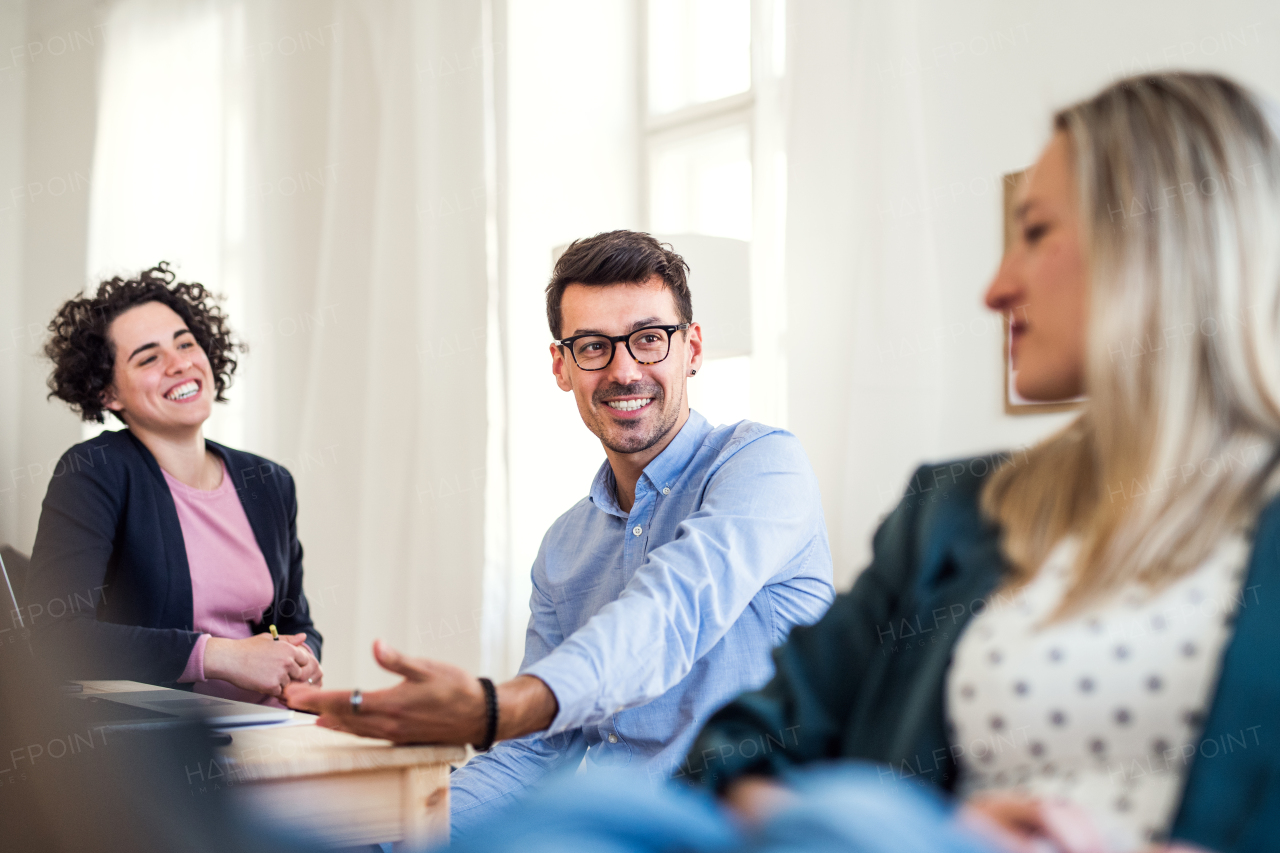 Group of young, cheerful, male and female businesspeople working together in a modern office.