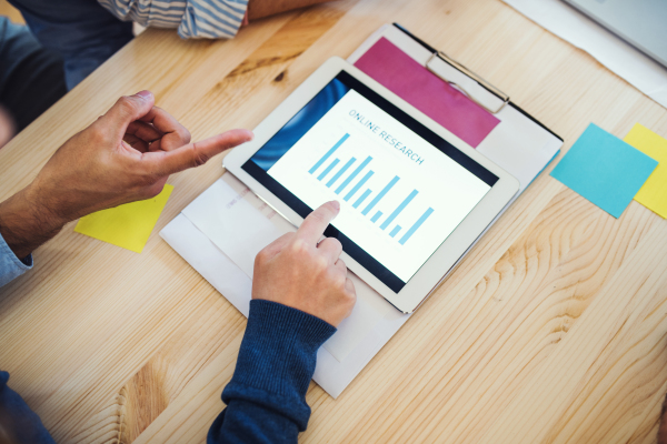 Group of businesspeople with tablet working together in office, a midsection view.