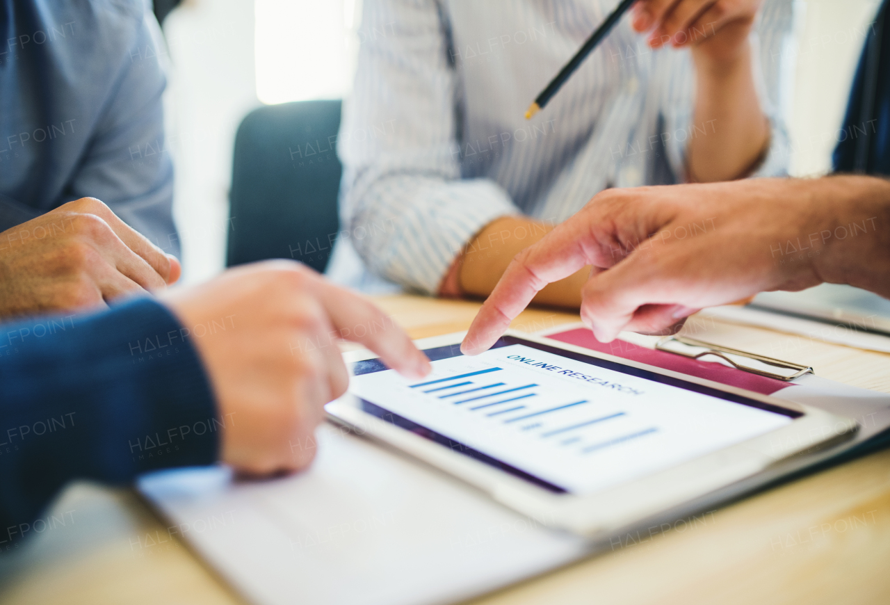 Group of businesspeople with tablet working together in office, a midsection view.