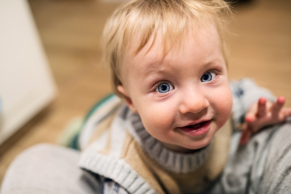 Top view of a cute toddler boy looking up at home. Close up.