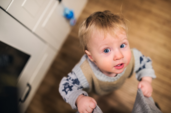 Top view of a cute toddler boy looking up at home. Close up.