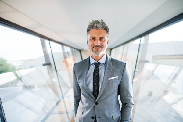 Handsome mature businessman walking in the corridor, travelling.