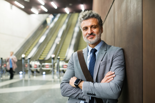 Handsome mature businessman in a city. Man standing at the subway station.