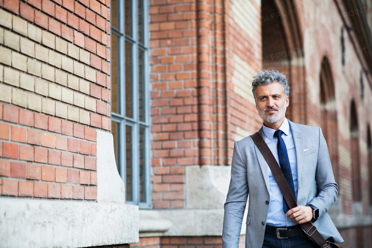 Handsome mature businessman walking in a city.