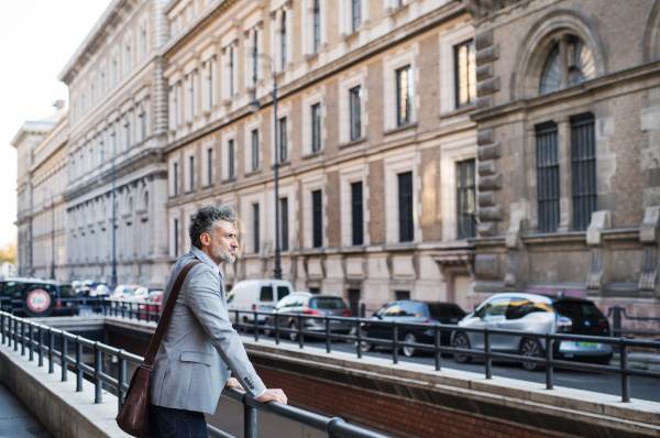 Handsome mature businessman standing in a city.