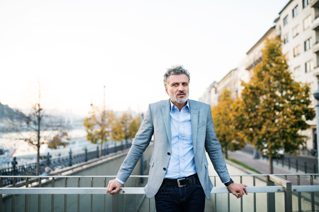 Handsome mature businessman in a city., taking a moment to relax