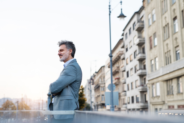 Handsome mature businessman in a city, taking a moment to relax.