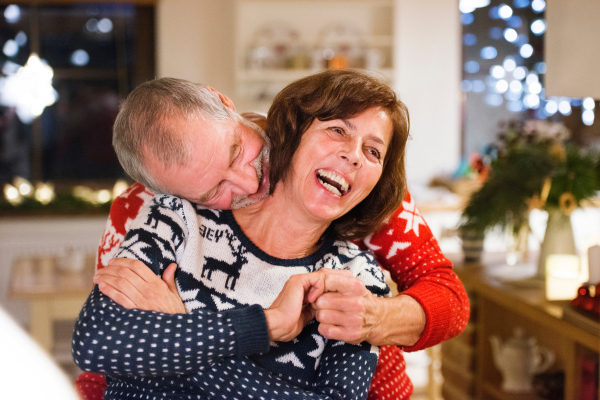 Beautiful senior couple in woolen sweaters with nordinc pattern at Christmas time.