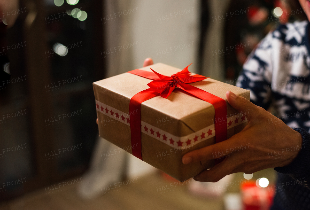 Unrecognizable senior woman holding a gift at Christmas time.