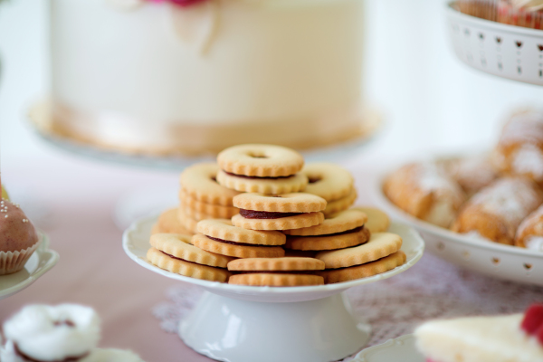 Close up, sandwich cookies filled with jam on ceramic cakestand. Studio shot.