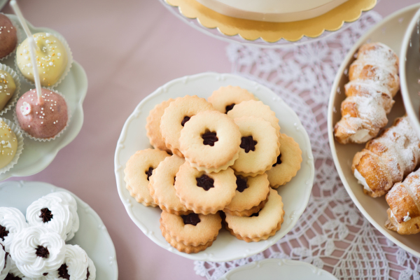 Jam cookies on cakestand, meringues, cakepops and horn pastries filled by whisked egg whites with sugar. Studio shot.