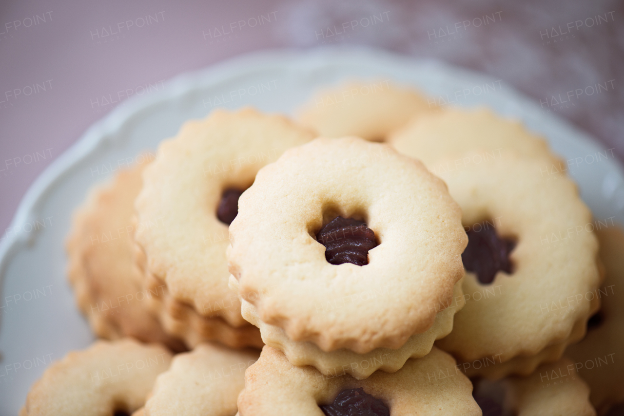 Close up, sandwich cookies filled with jam on cakestand. Studio shot.