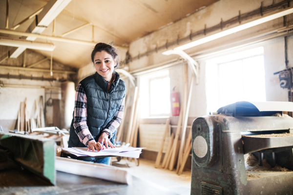 Portrait of a young woman worker in the carpentry workshop.