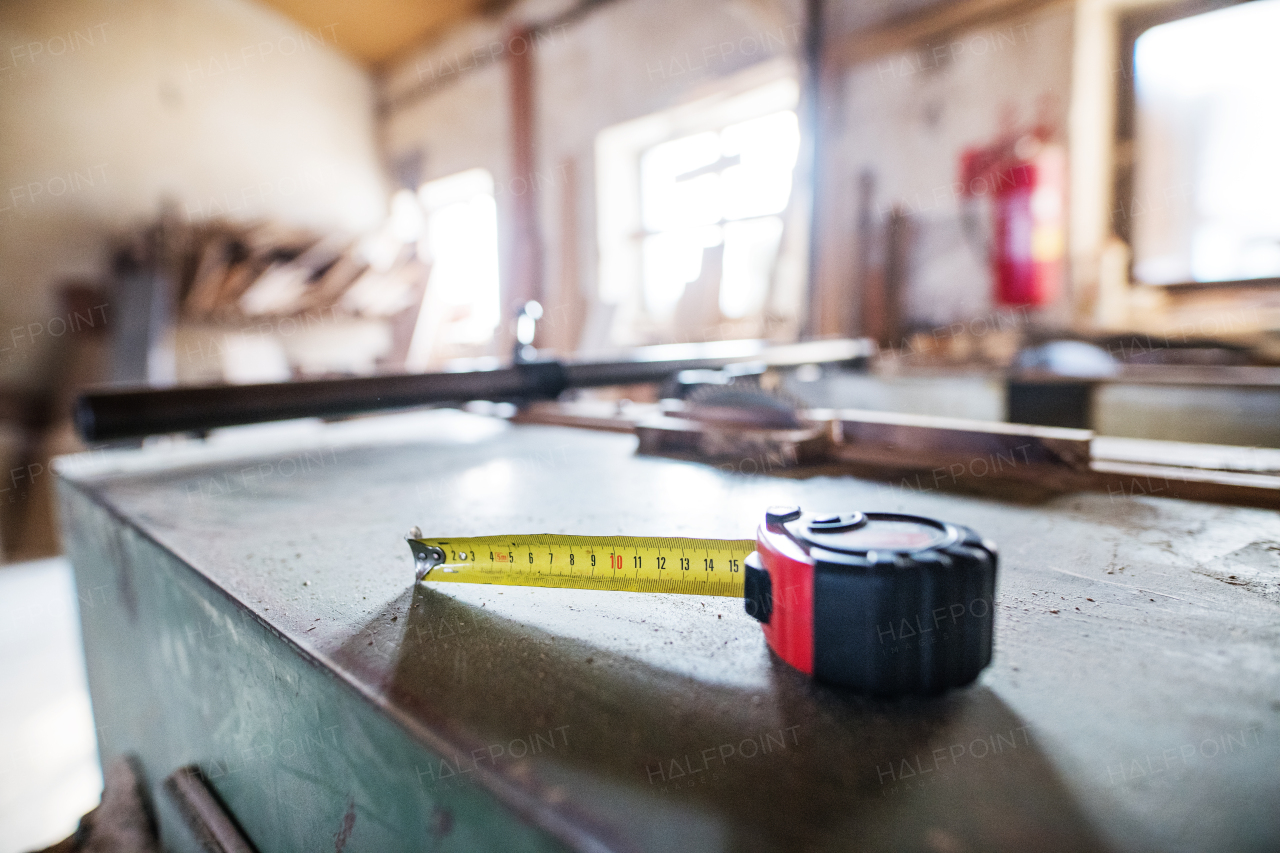 Aflexible ruler in carpentry workshop. Blurred background.