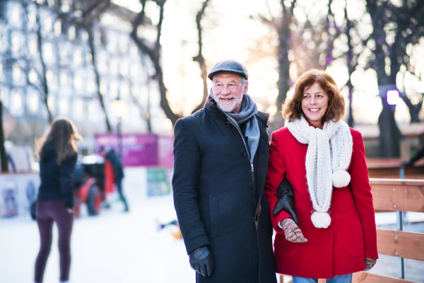 Happy senior couple on a walk in a city in winter.