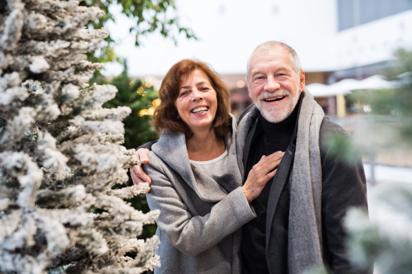 Senior couple doing Christmas shopping. Shopping center at Christmas time.