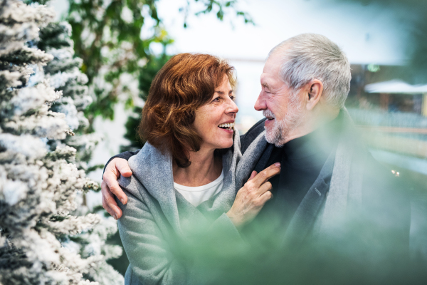 A portrait of happy senior couple in shopping center at Christmas time.