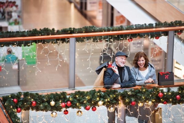 Senior couple doing Christmas shopping. Shopping center at Christmas time. High angle view.