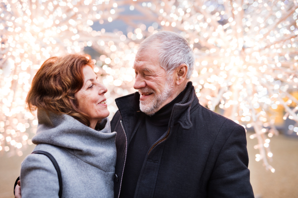 Senior couple doing Christmas shopping. Shopping center at Christmas time.