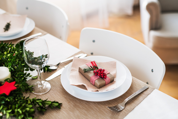 A close-up of a table set for a dinner at home at Christmas time.