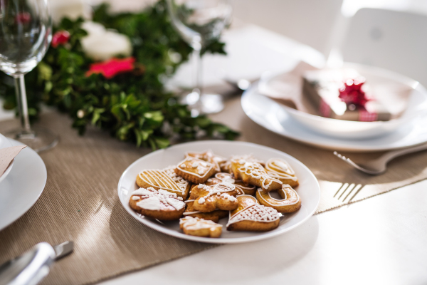 Gingerbread biscuits on a table set for a dinner at home at Christmas time.