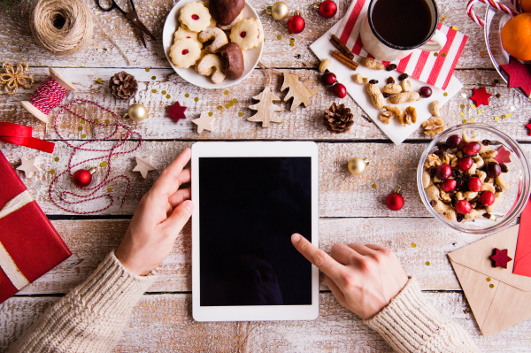 Christmas composition with tablet on a vintage wooden background. Flat lay. Copy space.