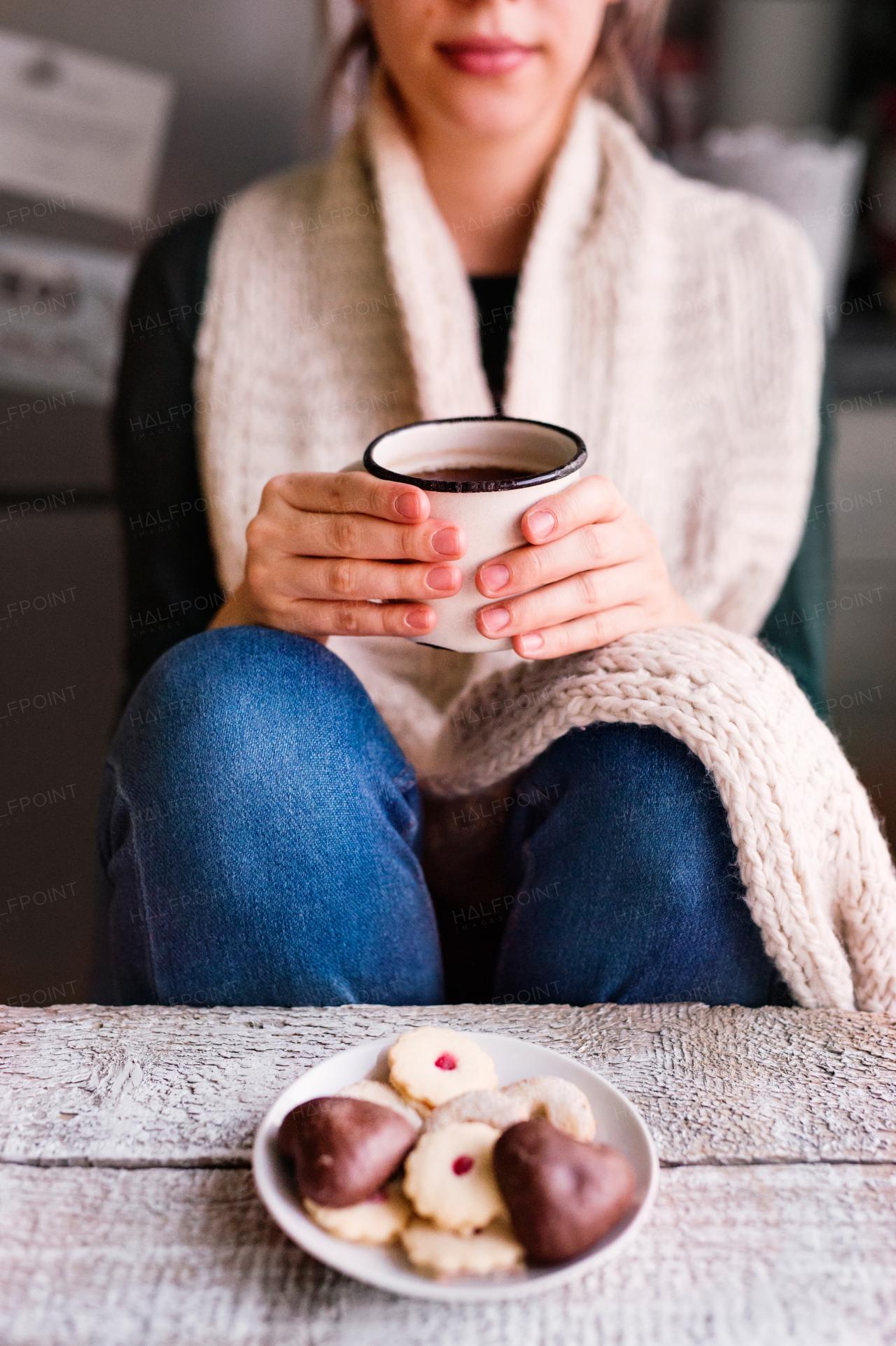 Unrecognizable young woman sitting and drinking coffee.