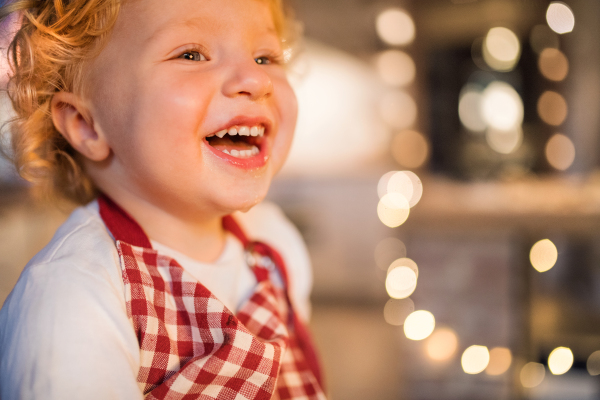 Happy toddler boy in the kitchen at Christmas time. Close up.