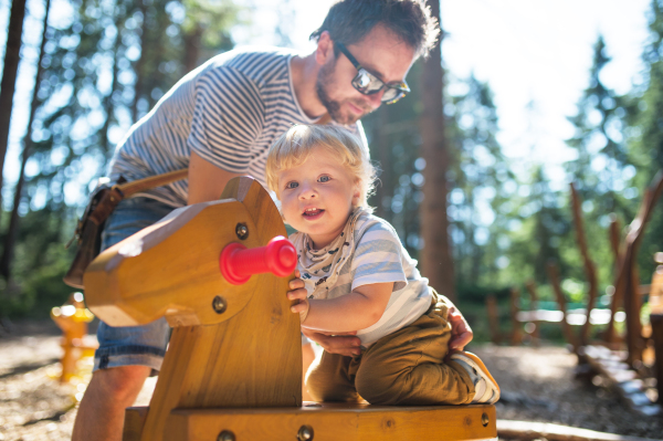 Young father with cute little boy on the playground.