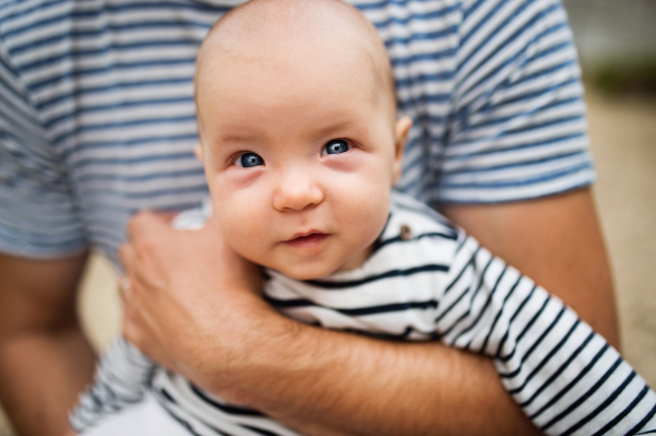 Unrecognizable father with a little baby, summer day.