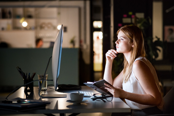 Beautiful young businesswoman in the office at night working late.