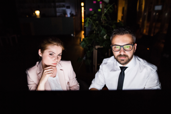 Young business people in the office at night working late.