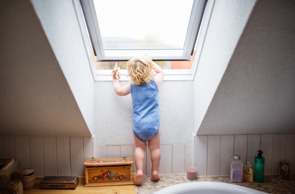 Little toddler boy opening a window. Domestic accident. Dangerous situation at home.