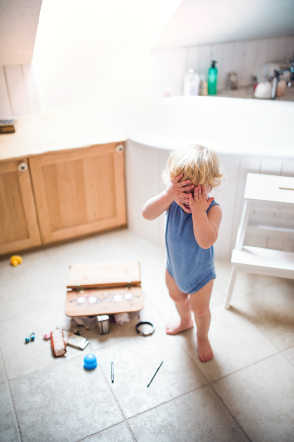 Little toddler boy in a dangerous situation in the bathroom.