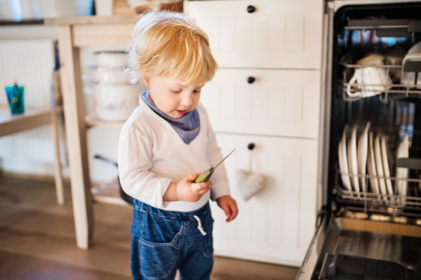 Little toddler boy holding a knife. Dangerous situation at home. Domestic accident. Child safety concept.