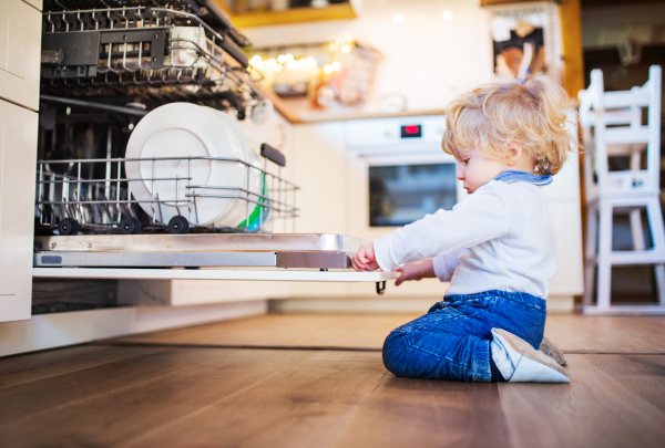 Little toddler boy in a dangerous situation at home. Domestic accident. Child safety concept.