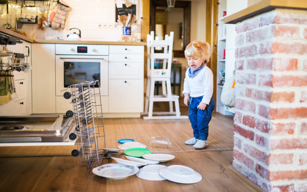 Little toddler boy in a dangerous situation at home. Domestic accident. Child safety concept.