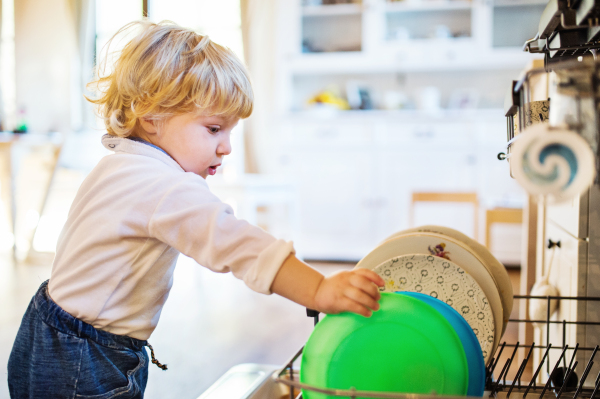 Little toddler boy in a dangerous situation at home. Domestic accident. Child safety concept.