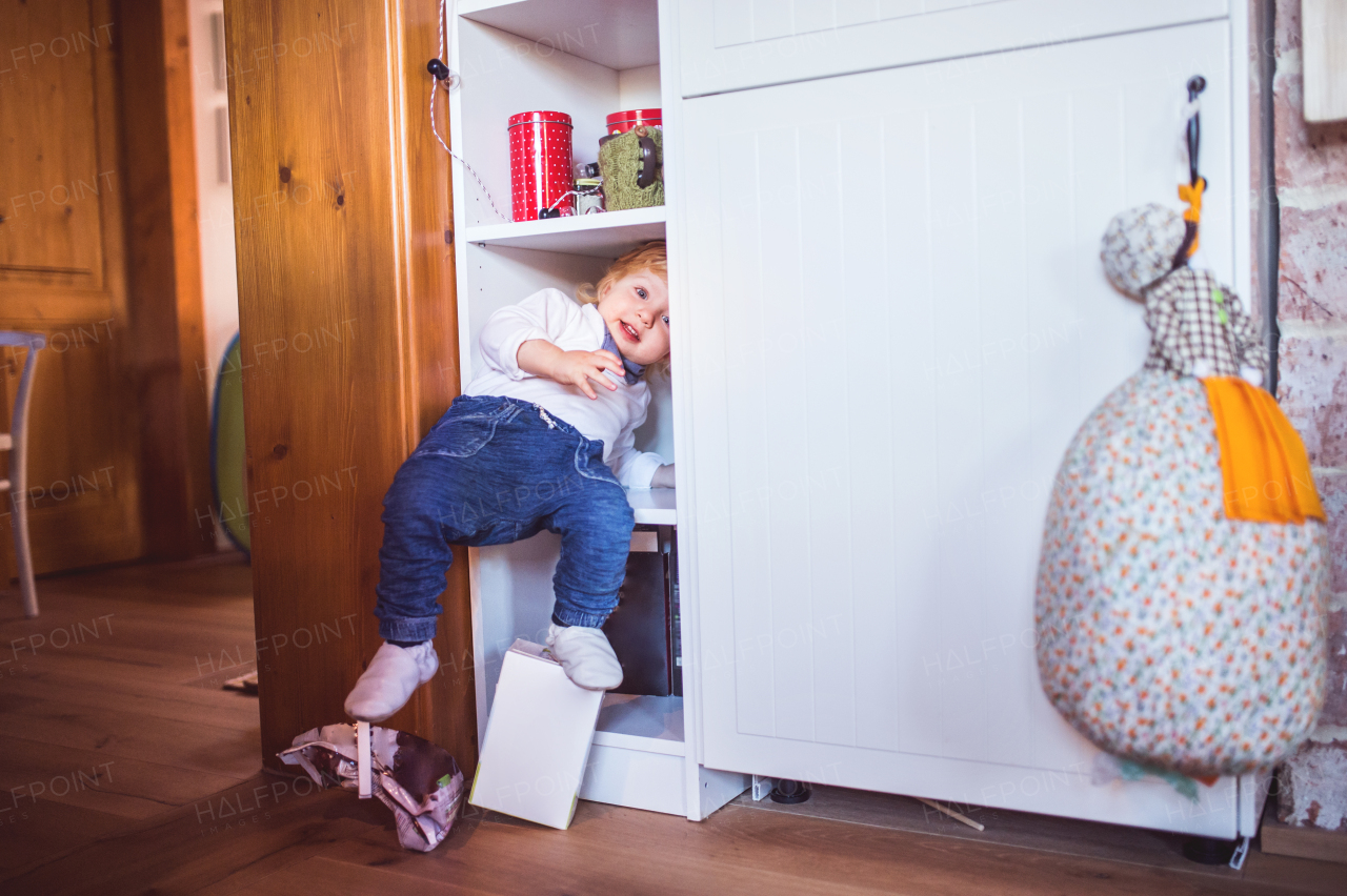 Toddler boy in a dangerous situation at home. Domestic accident. Child safety concept.