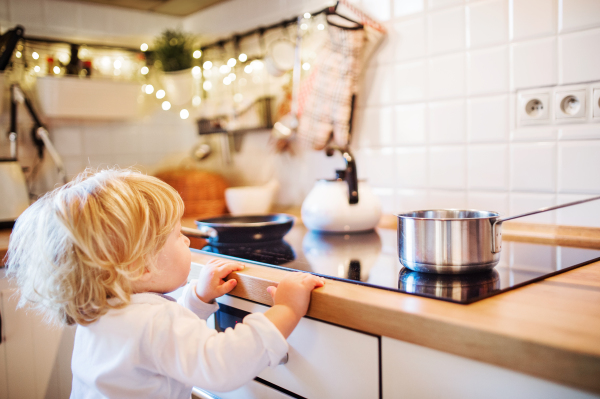 Toddler boy in a dangerous situation at home. Domestic accident. Child safety concept.