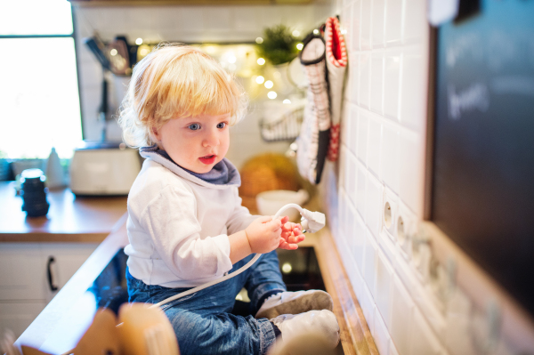 Toddler boy in a dangerous situation at home. Domestic accident. Child safety concept.