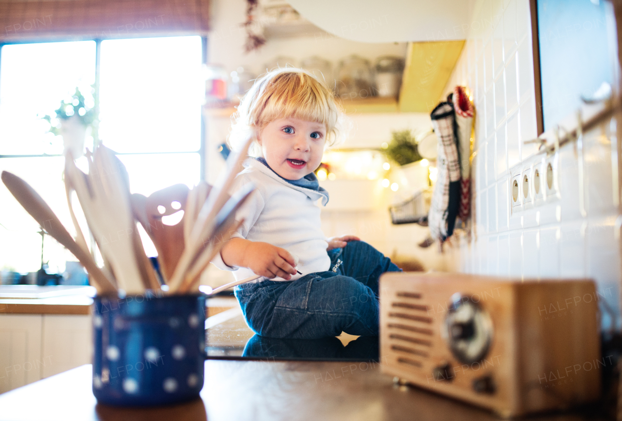 Toddler boy in a dangerous situation at home. Domestic accident. Child safety concept.