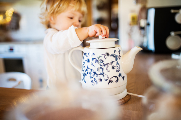 Toddler boy in a dangerous situation at home. Domestic accident. Child safety concept.